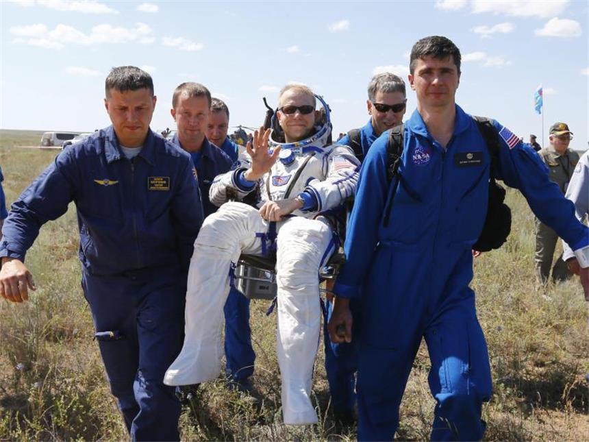 Drei Raumfahrer von der ISS zur Erde zurückgekehrt Der US-Amerikaner Timothy Kopra, frisch von der ISS zur Erde zurückgekehrt, wird von Helfern vom Landeplatz getragen. Foto: Shamil Zhumatov