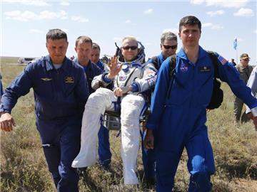 Der US-Amerikaner Timothy Kopra, frisch von der ISS zur Erde zurückgekehrt, wird von Helfern vom Landeplatz getragen. Foto: Shamil Zhumatov