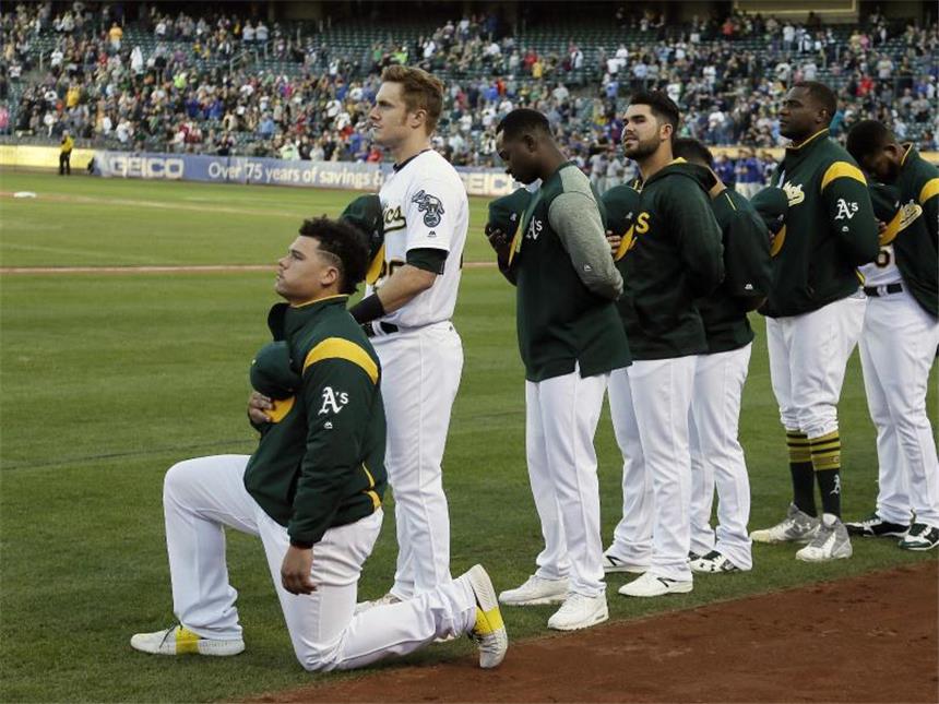 US-Sportler kontern Trump-Kritik - LeBron James: "Penner" Der US-amerikanische Baseball-Spieler Bruce Maxwell (l) kniet in Oakland während der US-Nationalhymne. Foto: Eric Risberg