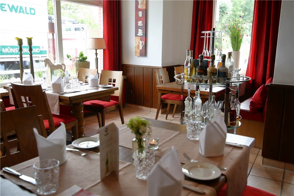 Der vordere Gastraum mit den rot gepolsterten Stühlen und der Bar hebt sich vom Rest des Restaurants ab.