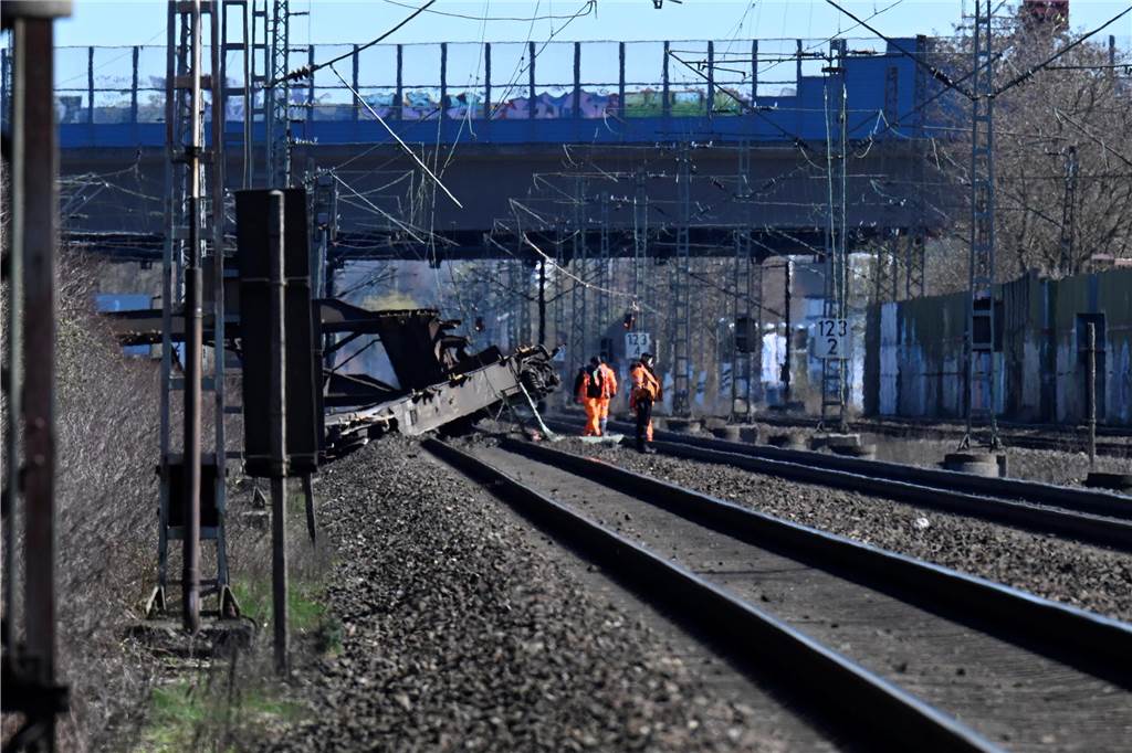 Zwei wichtige Bahnstrecken in NRW gesperrt : Güterwaggon entgleist - Züge müssen Umleitungen fahren Mitarbeiter der Deutschen Bahn begutachten einen aus den Gleisen gesprungenen Güterwaggon am Bahnhof Langerfeld.