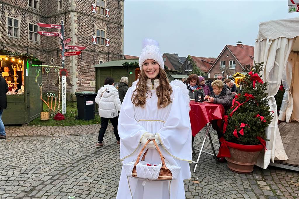 Der Weihnachtsengel hält einen Korb mit kleinen Geschenken in der Hand.