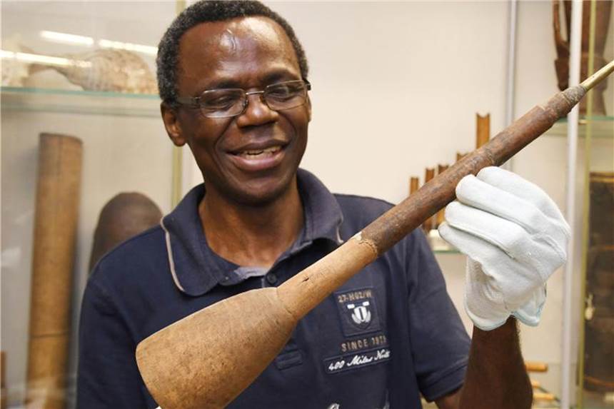 Der Wissenschaftler Ndzodo Awono zeigt im Übersee-Museum eine Schalmai aus Kamerun. Er fasst den Bestand von Objekten aus der Sammlung aus Kamerun zusammen. Foto: Carmen Jaspersen