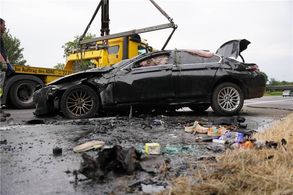 Schwerer Unfall auf der A2: BMW überschlägt sich und gerät in Brand Ein zerstörter BMW wird abtransportiert