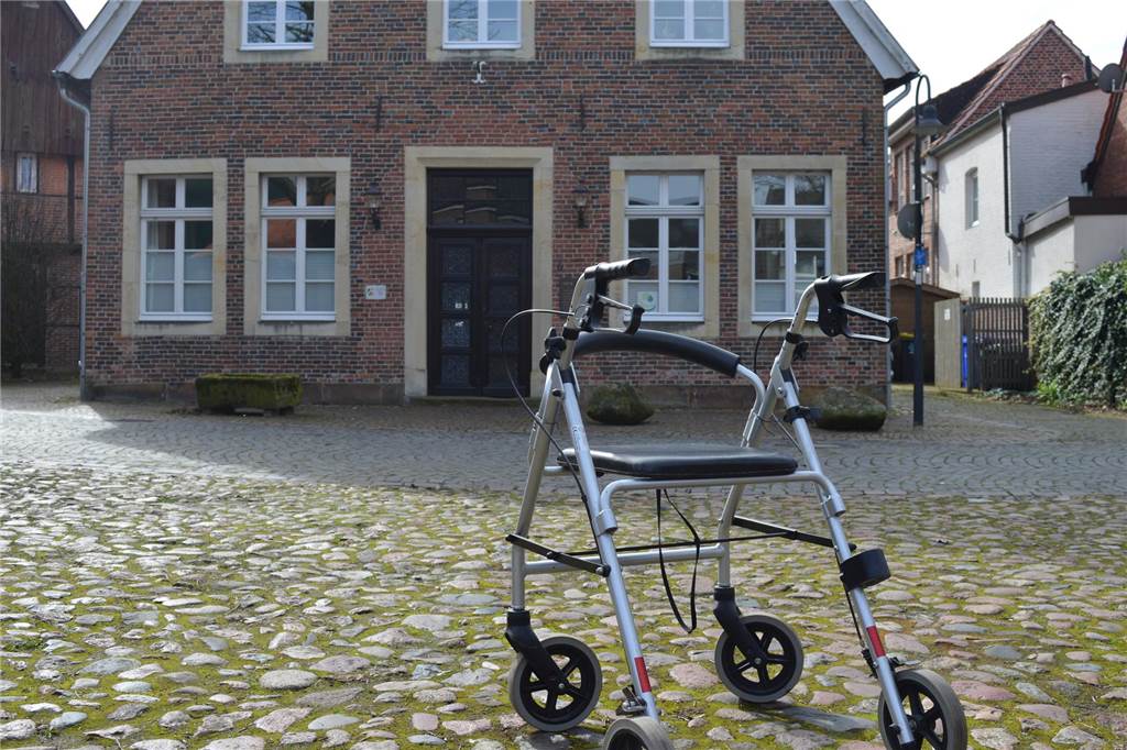 Ortswechsel oder Livestream? SPD-Antrag stößt auf Zustimmung und Kritik Ein Rollator steht auf dem Kopfsteinpflaster vor dem Haus Wessling im Legdener Busshook.