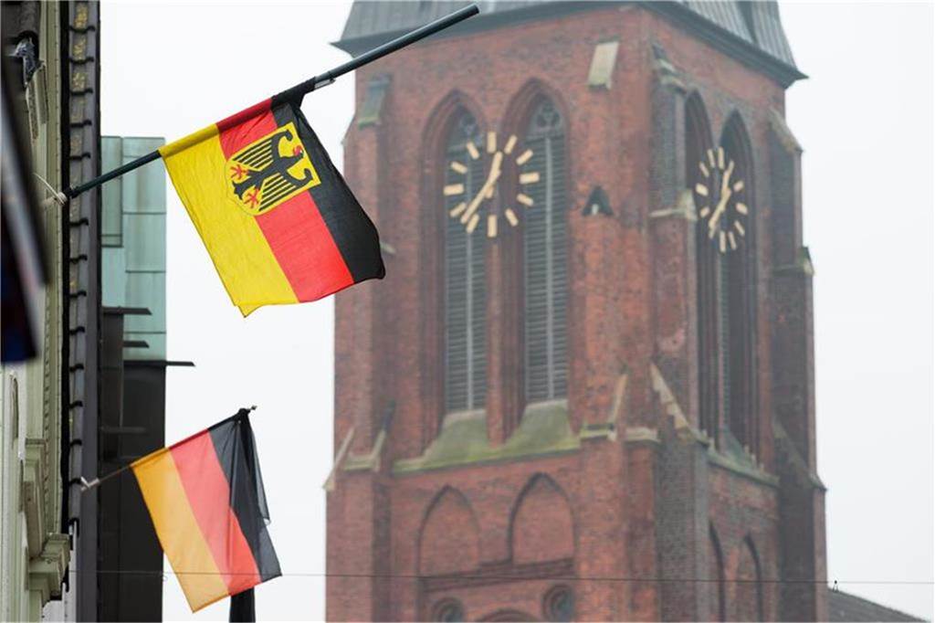 Deutsche Fahnen wehen vor der St.-Sixtus-Kirche in Haltern auf halbmast.
