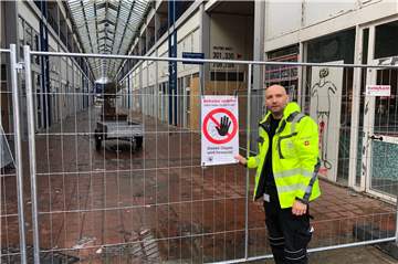 Die Absperrgitter an der Ladenpassage Wulfener Markt sollen vor Eindringlingen schützen. Und der Wachschutz von Deniss Recksing passt ebenfalls auf.