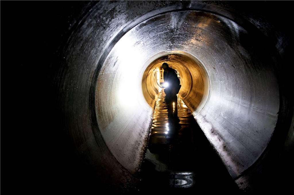 Abwasser-Urteil: Entlastung für Bürger, aber die Städte brauchen das Geld trotzdem Ein Mann inspiziert ein Abwasser-Rohr.