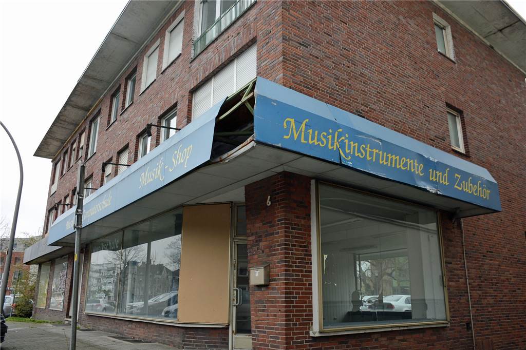 Verlassenes Wohn- und Geschäftshaus entwickelt sich zum Schandfleck in Dorsten Die alten Werbebanden bröckeln ab, die Schaufenster sind mit Spanplatten verkleidet.