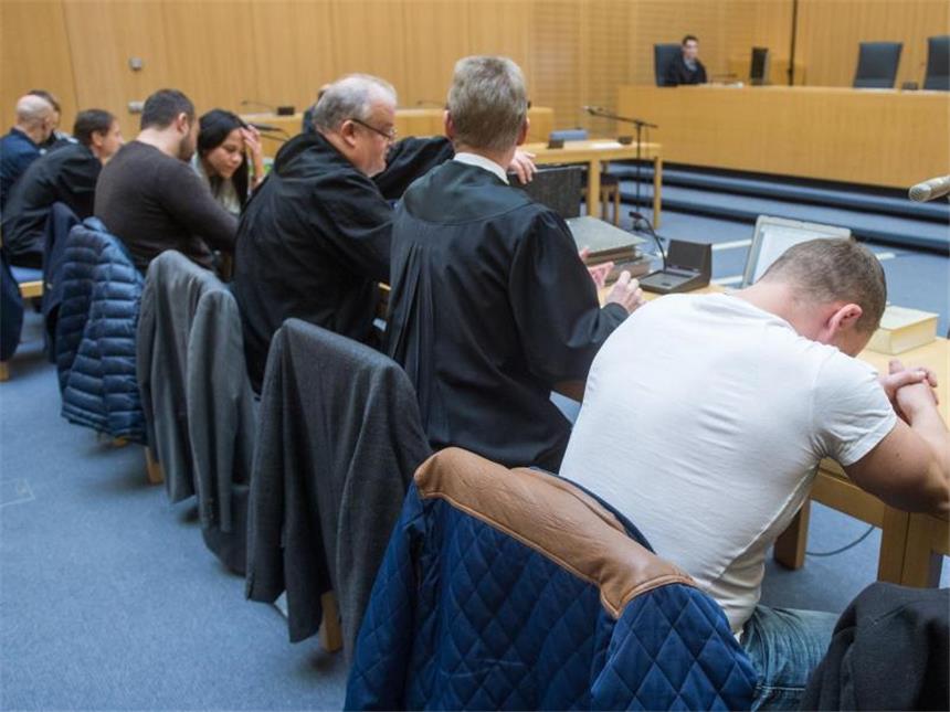 Die Angeklagten sitzen zwischen Anwälten und Dolmetschern im Gerichtssaal des Weidener Landgerichts. Foto: Armin Weigel/Archiv