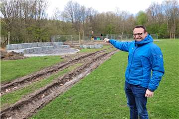 Der städtische Mitarbeiter Carsten Händschke zeigt auf die ersten Spielbereiche des neuen Waldspielplatzes an der verlängerten Buschstraße in Oer-Erkenschwick.