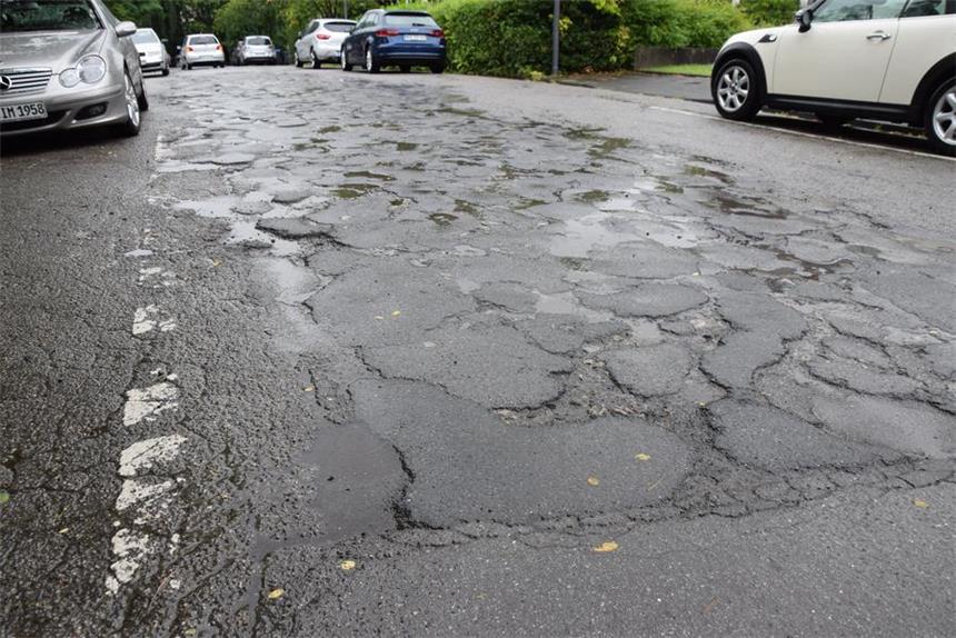 Die Asphaltdecke am Hangweg ist in einem verheerenden Zustand. Leserin Inge Schröder muss dreimal wöchenlich dort lang und hat Angst, ihr Auto dabei zu beschädigen.