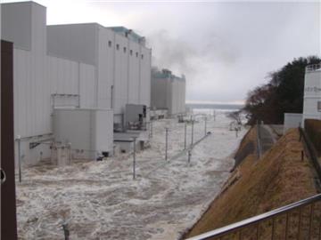 Die Aufnahme vom 11.03.2011 zeigt, wie die Fluten des Tsunami das Gelände des Atomkraftwerkes in Fukushima überflutet haben. Foto: Tepco