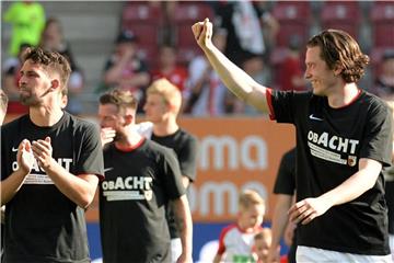 Die Augsburger Spieler feiern mit einem Spruch auf ihren Shirts den Klassenerhalt und das kommende 8. Bundesligajahr. Foto: Stefan Puchner