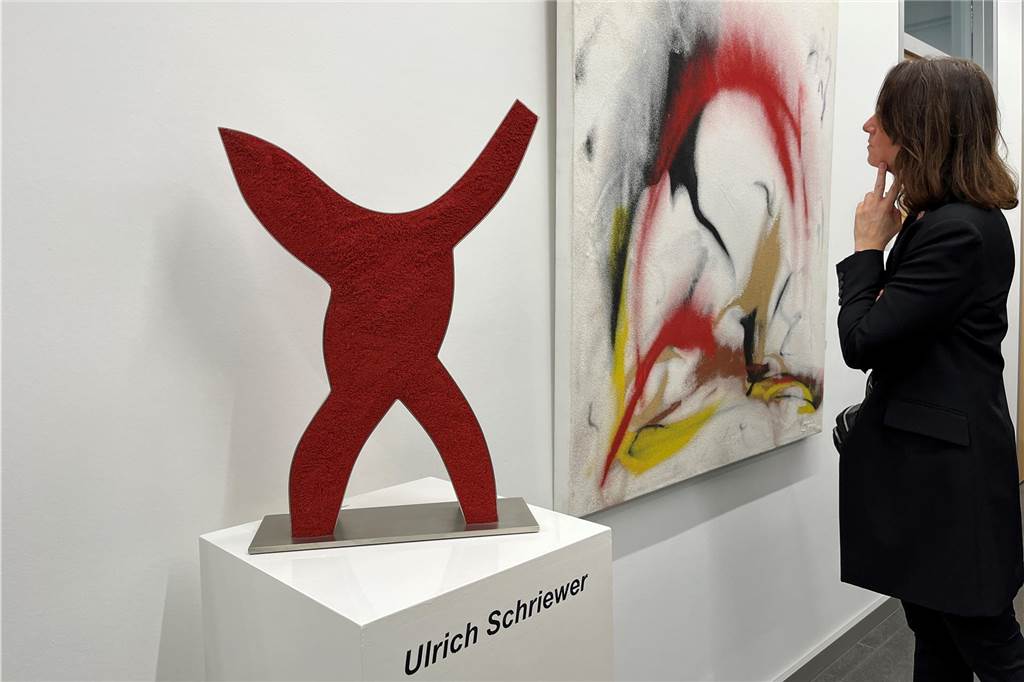 Sandkünstler Ulrich Schriewer: Licht, Schatten und fließende Formen Ein Gast betrachtet ein Bild der Ausstellung.
