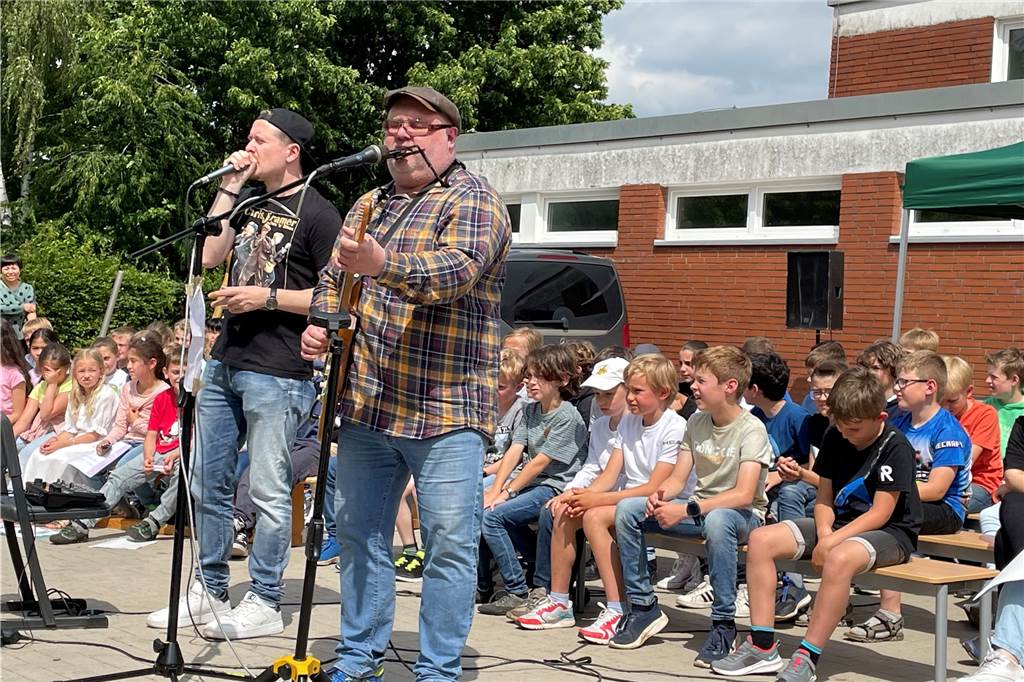 Dschungel statt Schule: Agatha-Schüler hatten tierisch viel Spaß bei Musikwoche Zwei Männer singen auf dem Schulhof der Agatha-Schule für die Kinder.
