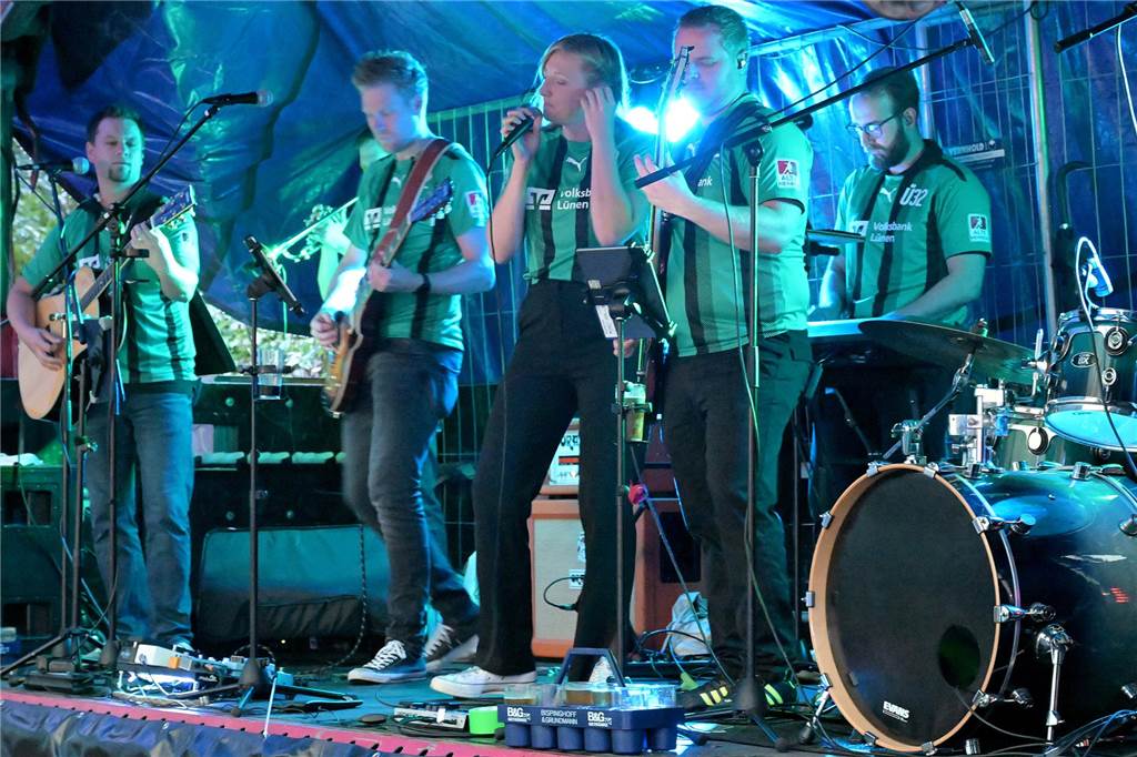 Fußball, XXL-Darts, Eigenes Bier: Die Jubiläumsfeier von Westfalia Wethmar in Bildern Die Band "Fireabend" steht in grün-schwarzen Trikots auf der Bühne.