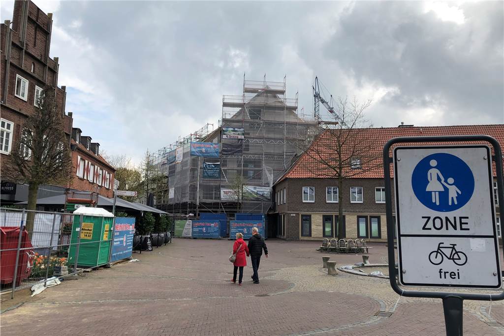 Mit Video: Großbaustelle am Vredener Markt – wann kommt das Extrablatt? Die Baustelle für das fünfgeschossige Wohn- und Geschäftsgebäude am Markt 1 von der Mitte des Marktplatzes aus gesehen. Über die Höhe des Hauses – 19,31 Meter – war im Vorfeld viel diskutiert worden in der Kommunalpolitik und der Bevölkerung.