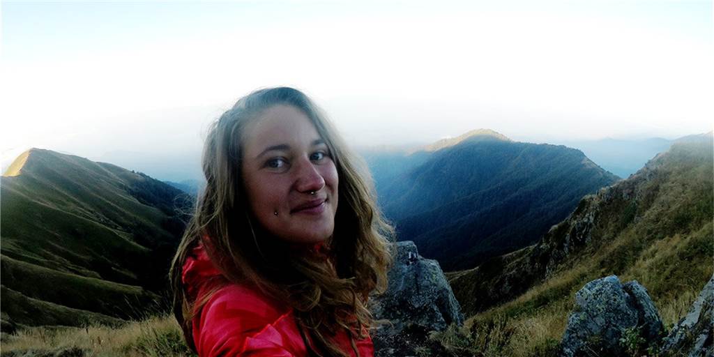Naturnah, aber meist verboten - Wo wildes Zelten dennoch möglich ist Die Bloggerin und Wildcamperin Jessi Fröde aus Dorsten steht hoch auf einem Berg.