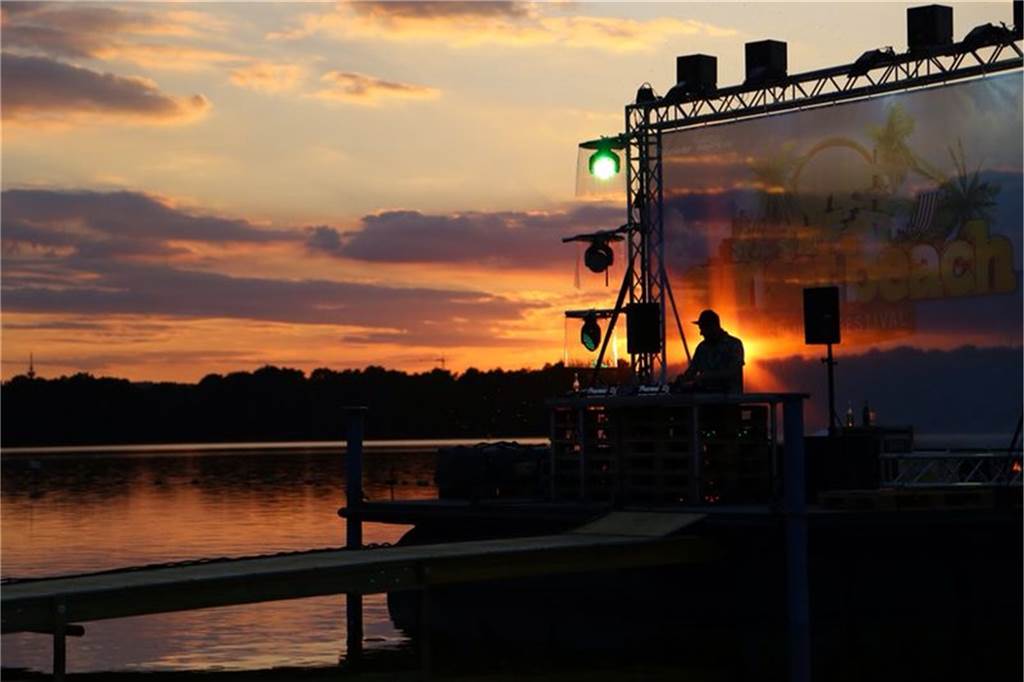 Das erste Sunset Beach Festival: Schlecht-Wetter-Prognosen und Mücken Die schwimmende Bühne ist im Vordergrund, dahinter geht die Sonne unter.