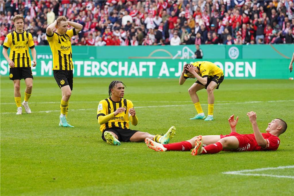 Nnamdi Collins sitzt auf dem Rasen.