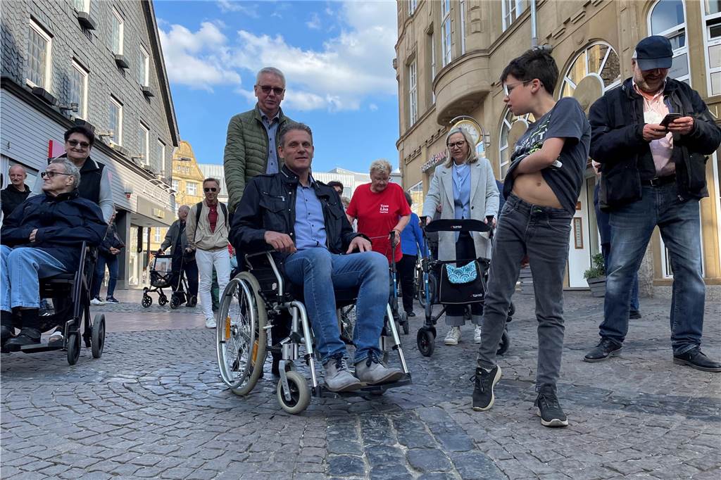 Straße zum Markt wird für Umbau gesperrt: Einzelhändler haben Kritik Menschen, teilweise in Rollstühlen und an Rollatoren, gehen über das Kopfsteinpflaster in der Fußgängerzone.