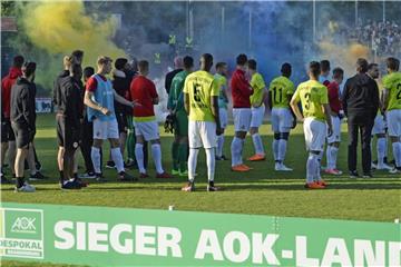 Die Cottbusser beobachten nach dem Pokalsieg die Pyroaktionen der Babelsberger Fans. Die Siegerehrung wurde abgebrochen. Foto: J. Kuppert