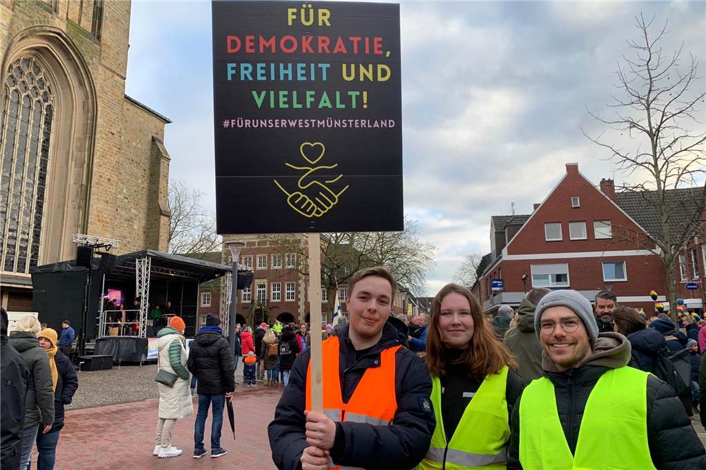 Buntes Zeichen: Voller Marktplatz bei Demonstration gegen Extremismus Demonstranten mit einem Plakat für Demokratie, Freiheit und Vielfal