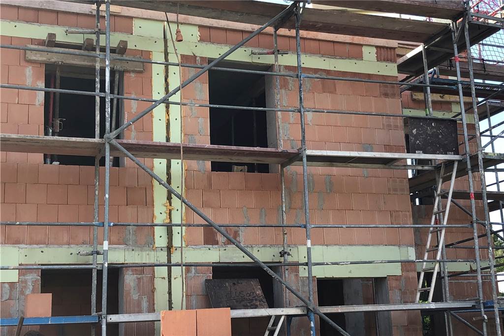 Die Doppelhaushälfte an der Heitkampstraße in Dortmund ist im Rohbau fertig. Auf diesem Foto sieht man die Dämmung zwischen den beiden Haushälften.