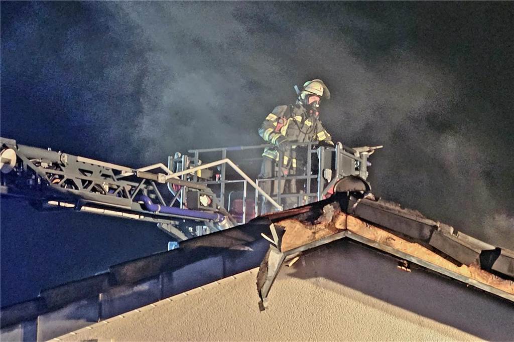 Die Drehleiter öffnete von außen die Dachhaut mit dem Einreißharken um an Glutnester im Firstbereich des Daches zu gelangen.