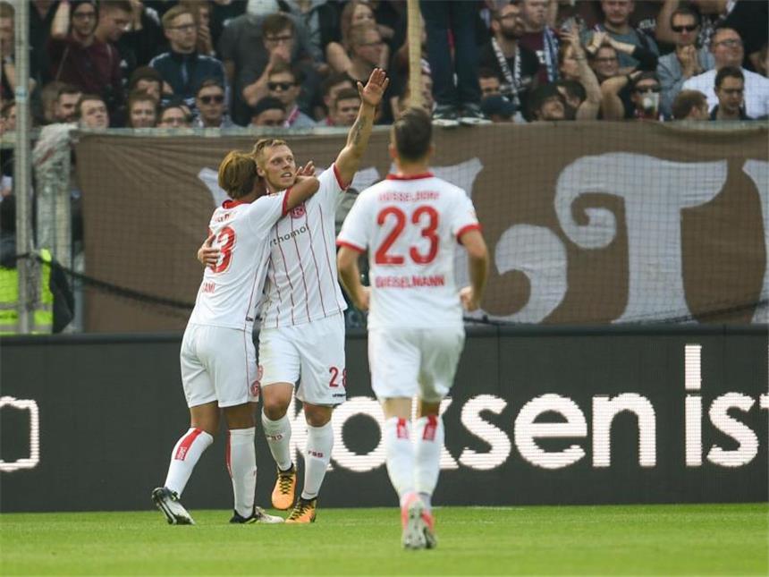 Perfekte Woche für Nürnberg - Düsseldorf wieder Spitze Die Düsseldorfer Takashi Usami (l-r), Torschütze Rouwen Hennings und Niko Gießelmann feiern auf St. Pauli. Foto: Axel Heimken