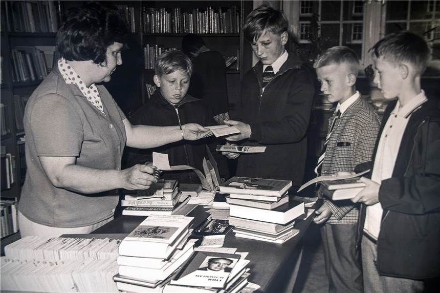 Ahauser Bücherei schreibt seit 65 Jahren Geschichte und zeigt das jetzt Die ehemalige Bibliotheksleitung Paula Verspohl mit einigen jungen Lesern.