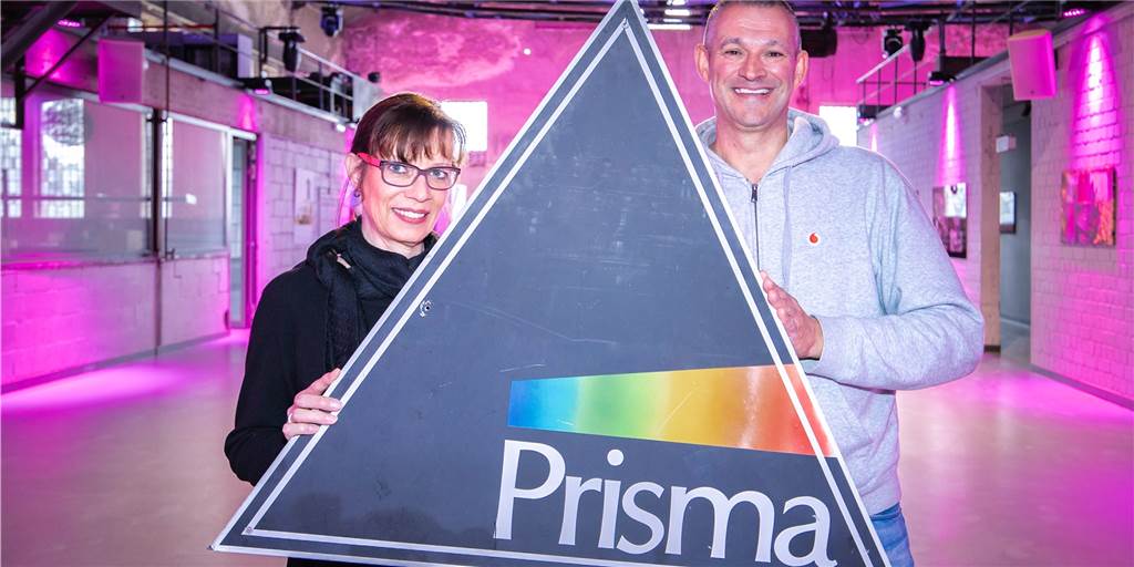 Revival-Partys lassen Erinnerungen an legendäre Diskothek „Prisma“ in Dorsten aufleben Die ehemalige Prisma-Mitbetreiberin Martina Tempelmann und Thomas Averkamp (DJ Tom) halten ein "Prisma"-Schild hoch.