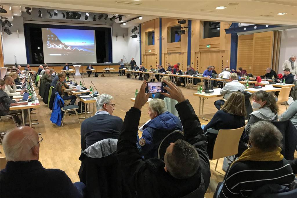 Mammutaufgabe in 2024: Diese Baustellen warten auf die Politik Bei einer Ratssitzung fotografiert ein Bürger die Politiker mit dem Smartphone.