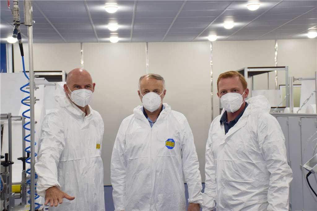 200.000 Schutzmasken pro Woche werden ab sofort in Heek produziert Die ersten FFP-2-Masken trugen beim offiziellen Produktionsstart (v.l.): Bürgermeister Franz-Josef Weilinghoff, Installateur Ludger Gausling und Sergej Ledowski (technischer Leiter FIT).