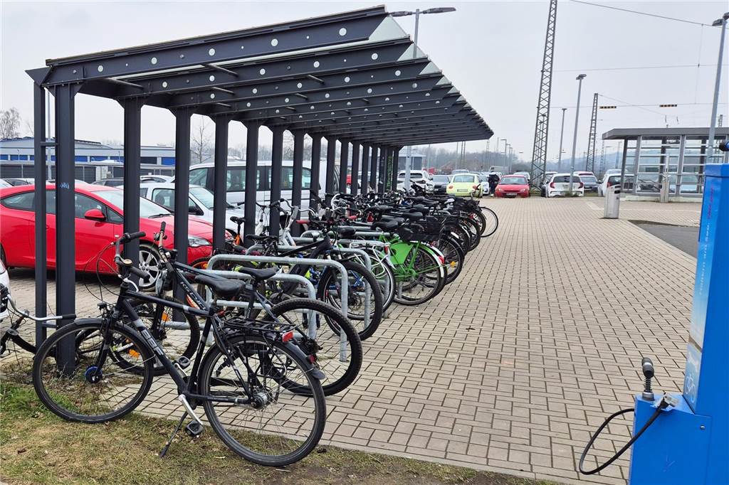 Unter einer Fahrrad-Abstellanlage stehen viele Fahrräder.
