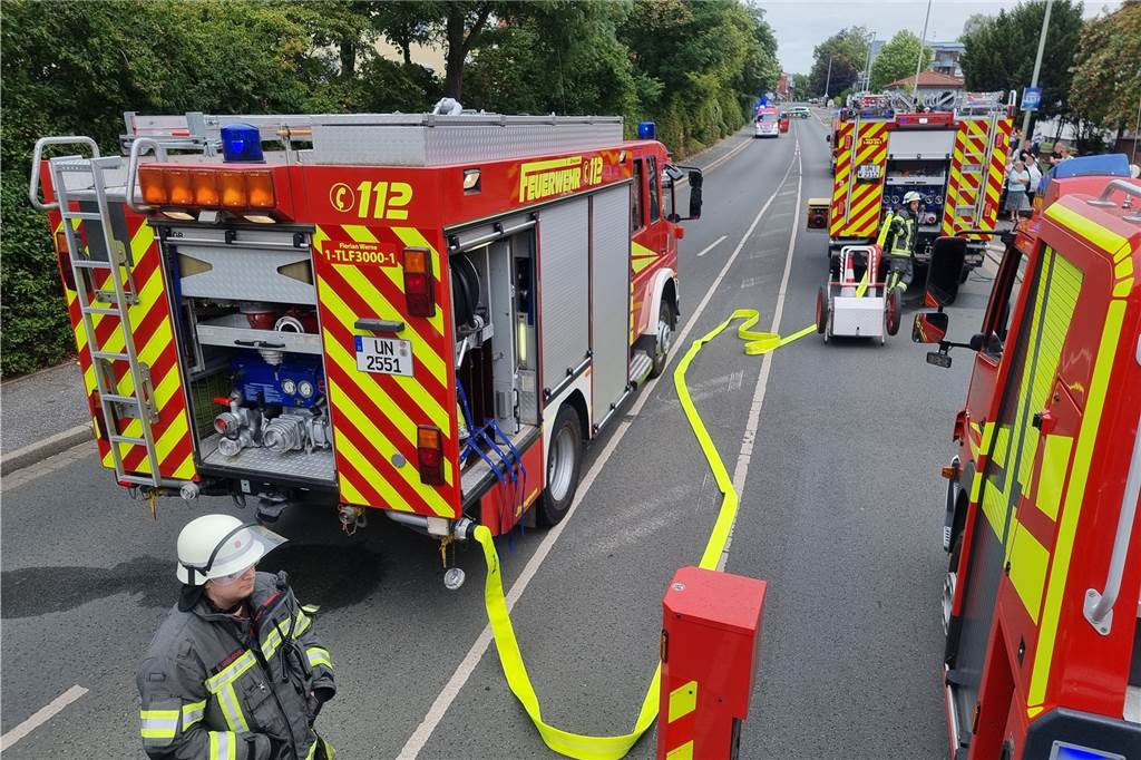 Brand im Mehrfamilienhaus Stockumer Straße: Dunst-Abzugshaube in Flammen Feuerwehrautos stehen auf einer Straße.