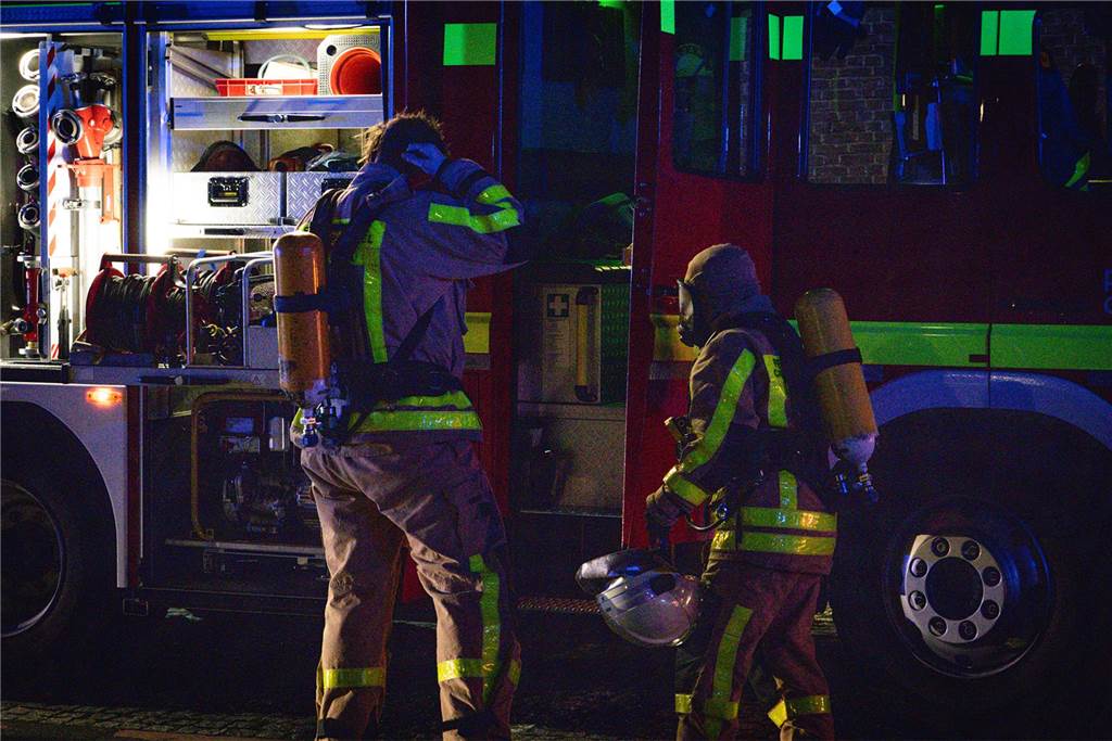Feuerwehrleute und Einsatzfahrzeuge beim Löschen des Brandes im Westfälischen Landestheater an der Stadthalle Castrop-Rauxel. 