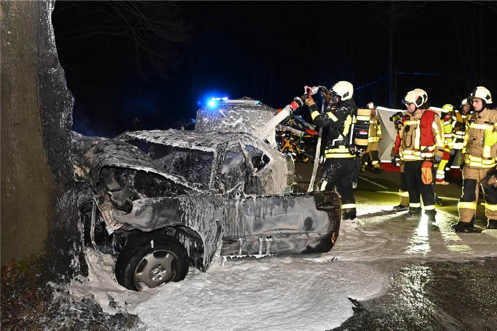 Tödlicher Unfall: Auto prallt gegen einen Baum und fängt Feuer Die Feuerwehr löschte das brennende Auto mit Schaum.