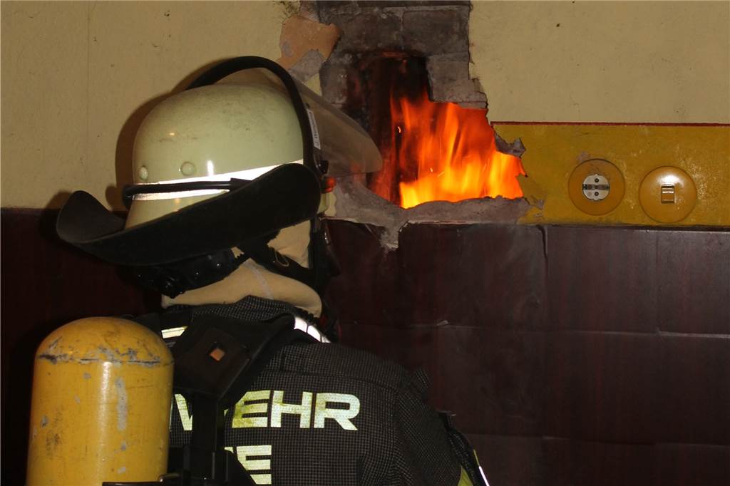 Brandalarm in Werne: Feuerwehr muss verstopften Kamin aufstemmen Ein Feuerwehrmann vor einer Flamme.