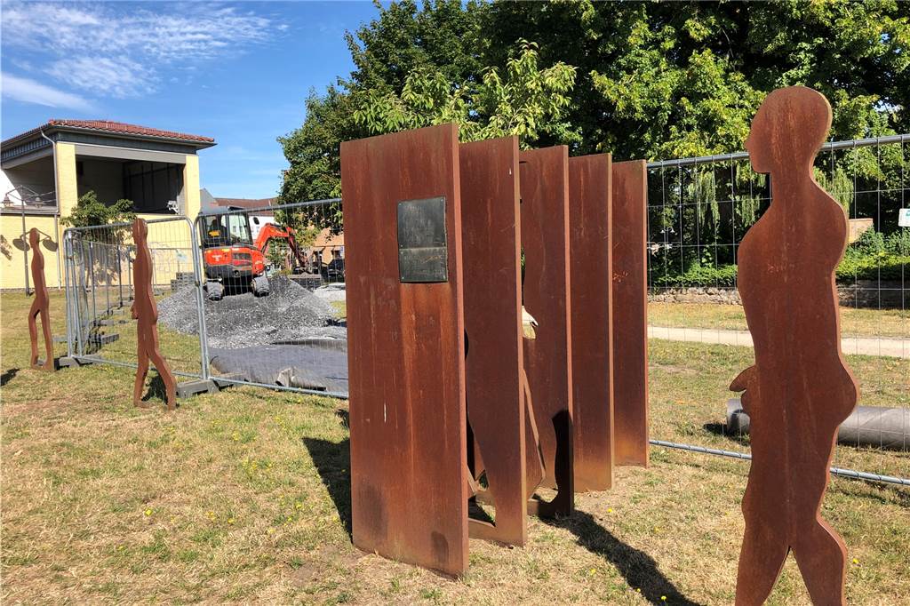 Die Figuren vor der Burg Botzlar bleiben außerhalb der Umzäunung. Dahinter schafft ein Bagger eine Baustraße.