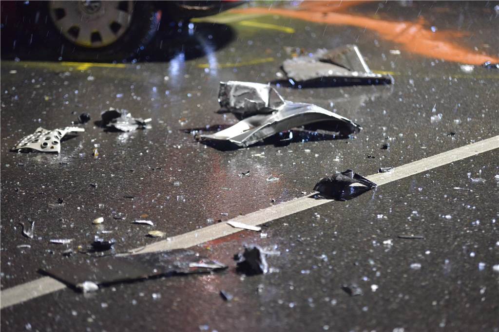 Trümmerteile liegen nach einem Verkehrsunfall auf der Altenbruchstraße in Waltrop auf der Straße.