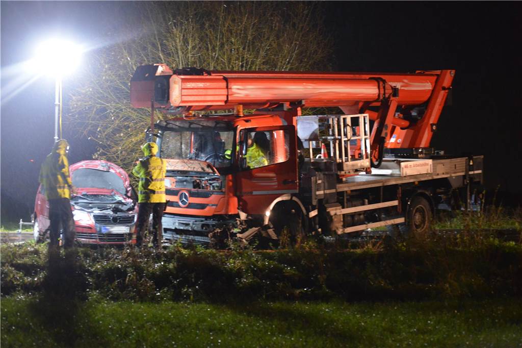 Auf der Altenbruchstraße in Waltrop stehen bei Dunkelheit ein verunfallter roter Lkw und ein verunfallter roter Pkw.