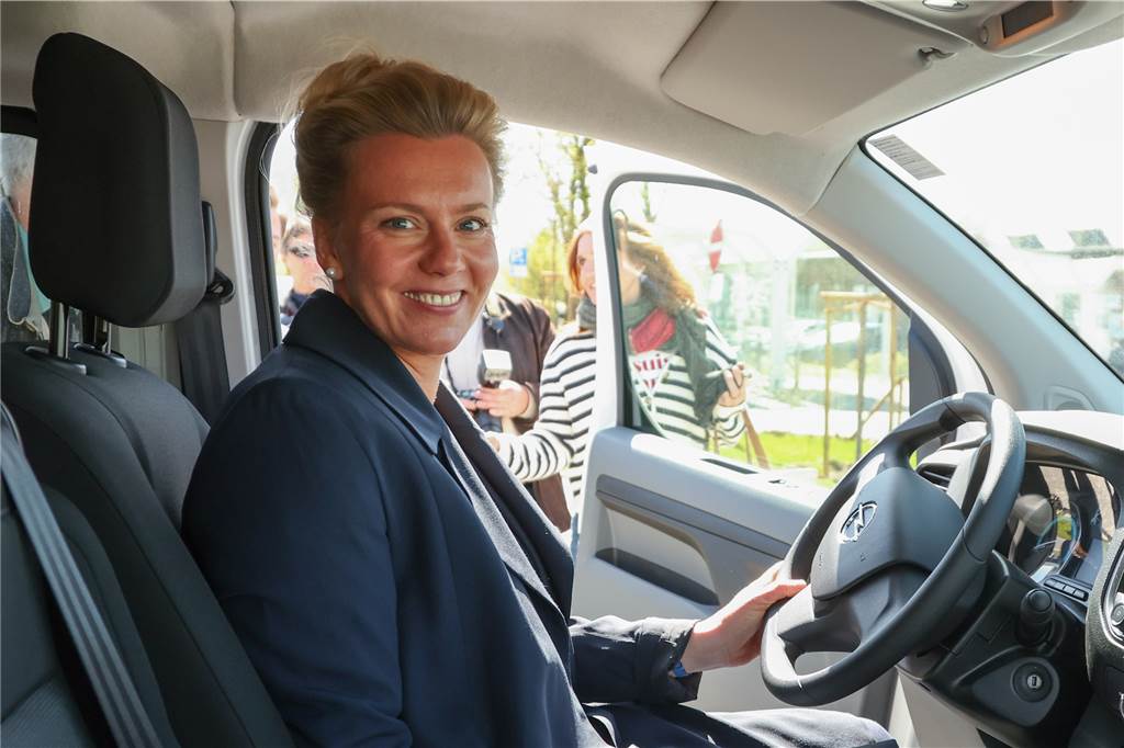 Ina Brandes (CDU), Verkehrsministerin von Nordrhein-Westfalen, sitzt in einem Elektro-Fahrzeug bei der Besichtigung vom Linien-E-Carsharing am Bahnhof Borgholzhausen. 