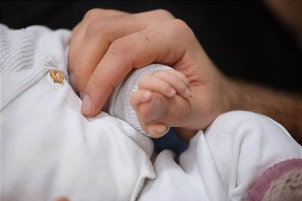 GNTM-Kandidatin: „Ich dachte, die Welt würde sich nie weiterdrehen“ Eine Männerhand hält eine Baby-Hand.