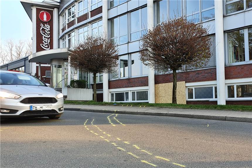 Auto kracht ins Hertener Coca-Cola-Gebäude – Feuerwehr und Polizei im Einsatz Die gelben Sprühmarkierungen zeigen die Spur des Autos, bevor es schließlich in die Fassade des Coca-Cola-Gebäudes krachte. Das dabei entstandene Loch wurde inzwischen mit einem Holzbrett verschlossen.