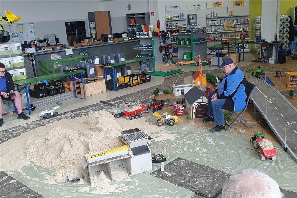 Modellbauer sitzen in einer Halle bei der  Gewerbeschau „Let’s go West“ in Ascheberg 2023.