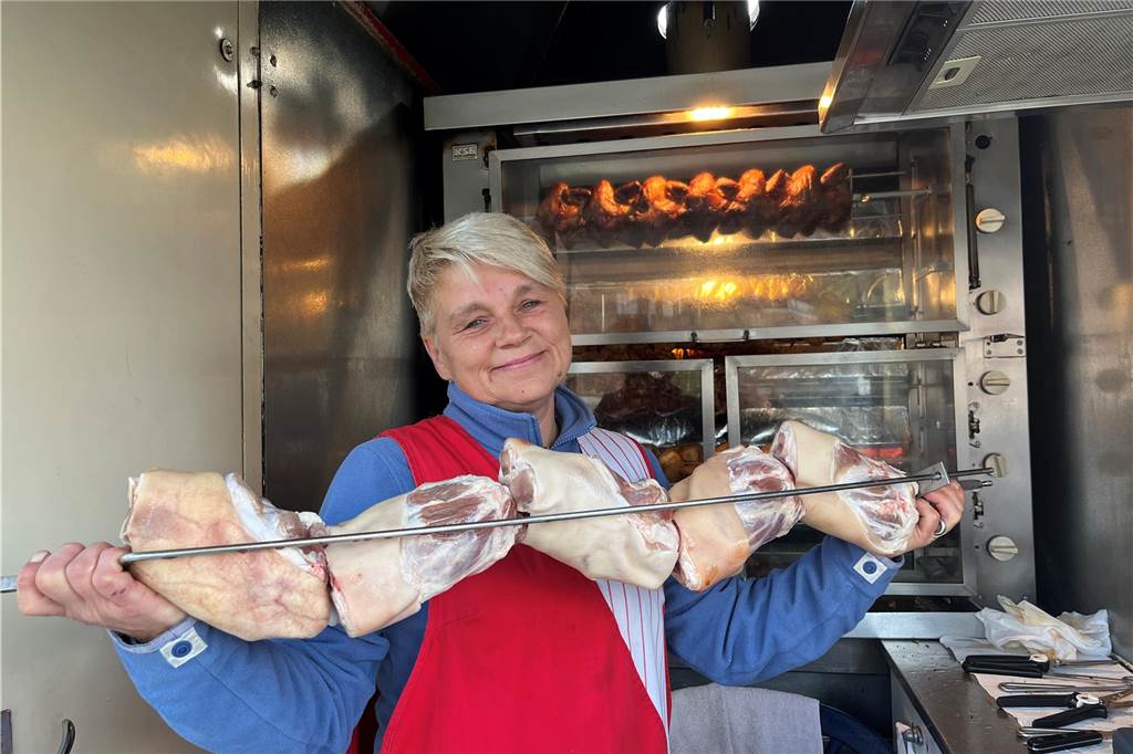 Mobil-Imbiss in Sythen: Das ist das Geheimnis gut gegrillter Hähnchen Martina Rüter zeigt rohe Schweinehaxen, die auf einen Grillstab aufgezogen sind.