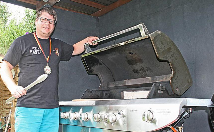 Die Grillzange in der Hand, die Goldmedaille um den Hals: Jörn Fischer aus Habinghorst - hier am heimischen Grill - ist Deutscher Meister im Grillen.