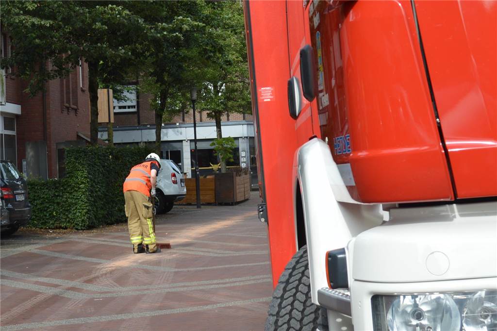 Feuerwehreinsatz: Kilometerlange Ölspur schlängelt sich durch die Stadt Ein Feuerwehrmann fegt Ölbindemittel auf einer Ölspur.